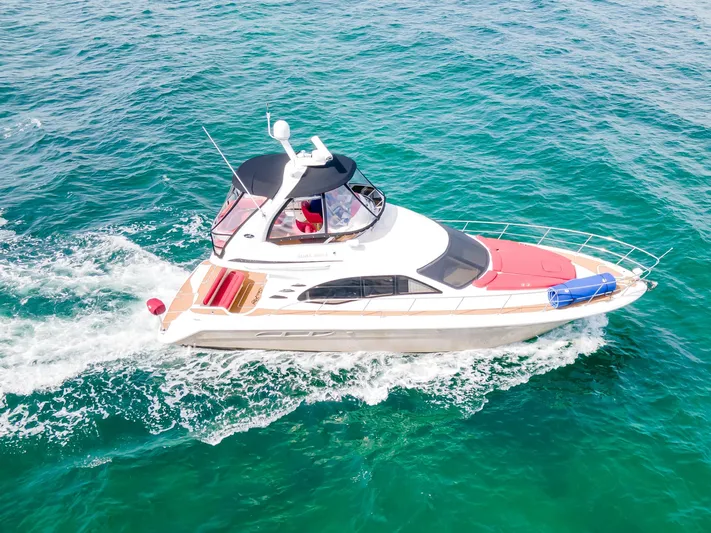  Yacht Photos Pics 2006 Sea Ray 44 Sedan Bridge cruising on clear turquoise waters.