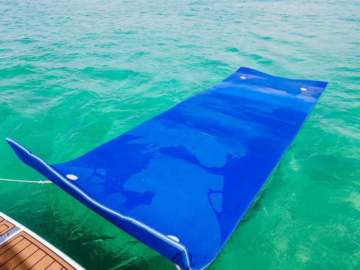  Yacht Photos Pics Blue floating mat on turquoise water near a 2006 Sea Ray 44 Sedan Bridge.