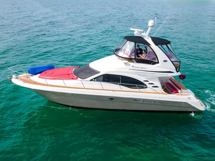  Yacht Photos Pics 2006 Sea Ray 44 Sedan Bridge yacht cruising on clear turquoise water.