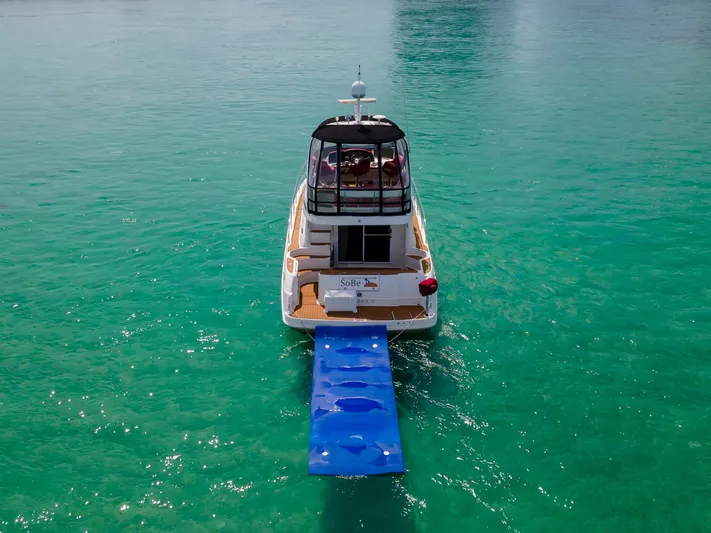  Yacht Photos Pics 2006 Sea Ray 44 Sedan Bridge yacht on turquoise water with blue floating mat.