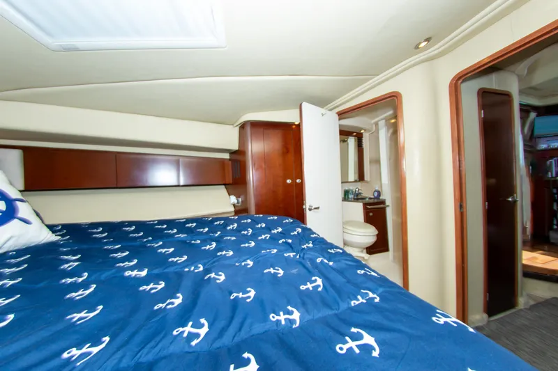  Yacht Photos Pics Interior of 2006 Sea Ray 44 Sedan Bridge with nautical-themed bedding and ensuite bathroom.