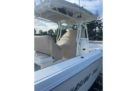  Yacht Photos Pics 2017 Sailfish 320 CC boat with covered seating, docked on a calm waterway.