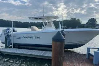  Yacht Photos Pics 2017 Sailfish 320 CC boat docked, named "Chasing Tail," under a cloudy sky.