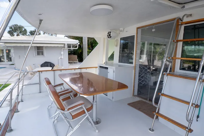Masterplan Yacht Photos Pics 1975 Hatteras 58 YF yacht deck with table, chairs, and ladder.