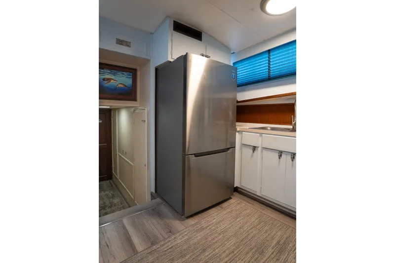 Masterplan Yacht Photos Pics 1975 Hatteras 58 YF yacht kitchen with stainless steel fridge and white cabinets.