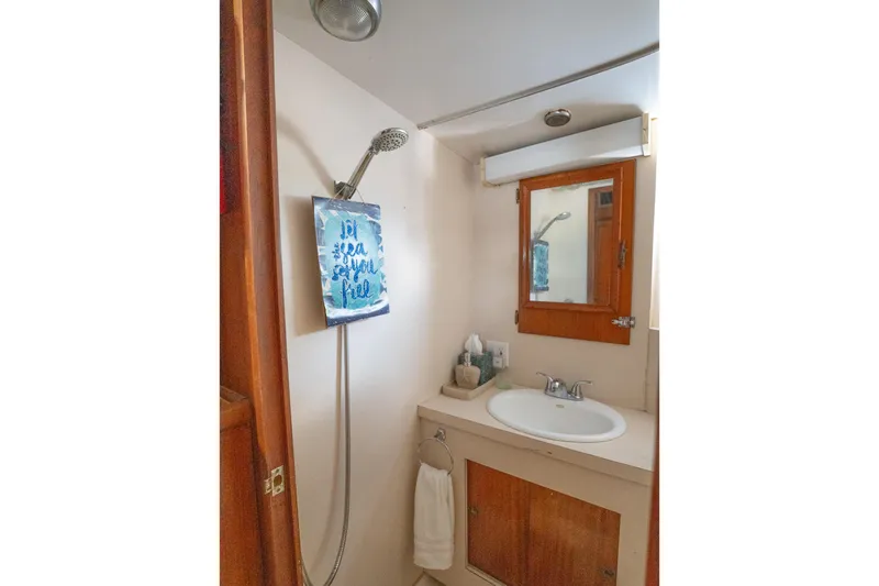 Masterplan Yacht Photos Pics 1975 Hatteras 58 YF yacht bathroom with shower, sink, and wooden cabinetry.