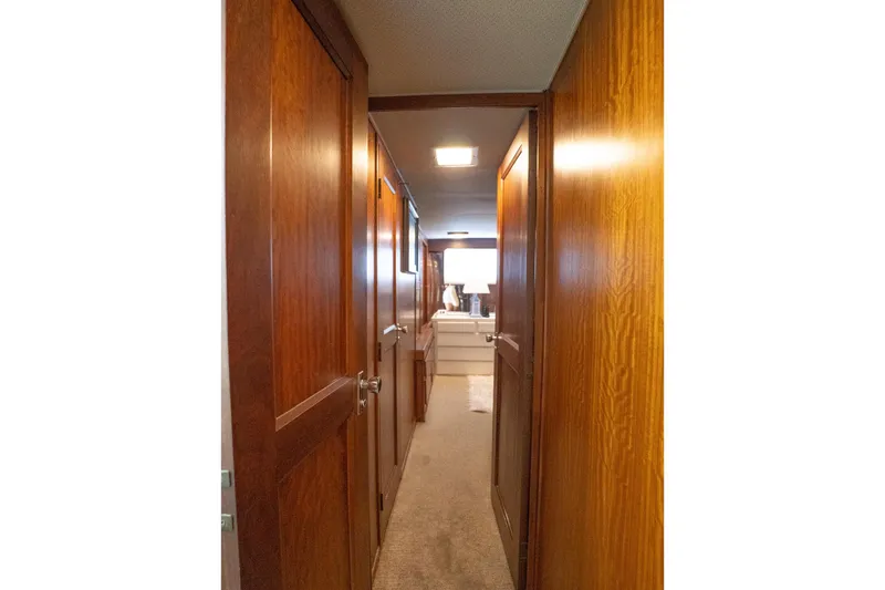 Masterplan Yacht Photos Pics Interior hallway of 1975 Hatteras 58 YF yacht with wooden paneling and carpeted floor.