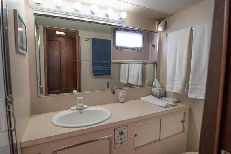 Masterplan Yacht Photos Pics Bathroom interior of 1975 Hatteras 58 YF yacht with sink, mirror, and towels.