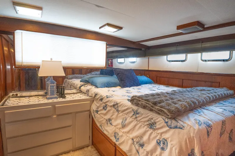 Masterplan Yacht Photos Pics Cozy bedroom interior of 1975 Hatteras 58 YF yacht with nautical-themed bedding.