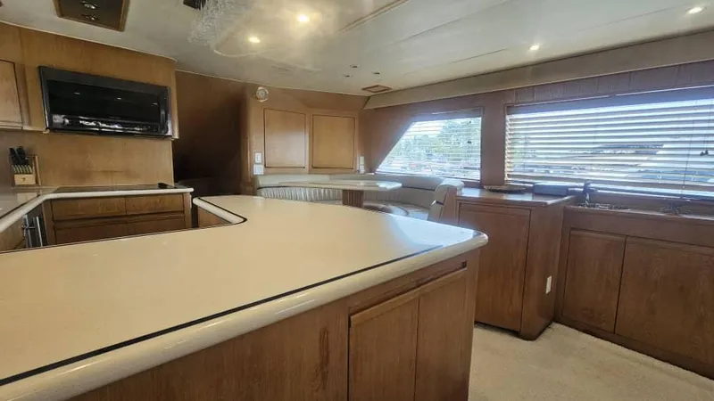  Yacht Photos Pics Interior of 1999 Hatteras 65 Convertible yacht with spacious kitchen and wooden cabinetry.