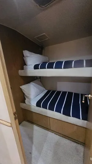  Yacht Photos Pics Bunk beds in 1999 Hatteras 65 Convertible yacht cabin with striped bedding.