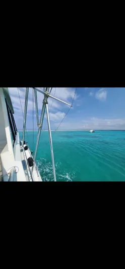  Yacht Photos Pics Hatteras 65 Convertible yacht cruising on clear turquoise waters, 1999 model.