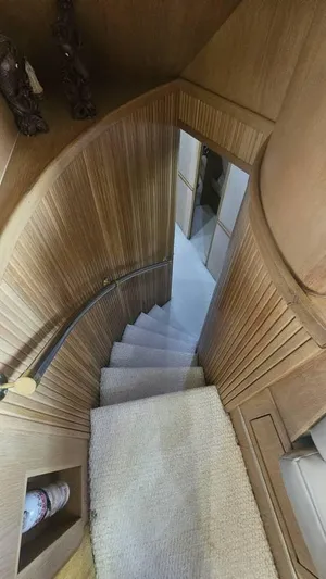  Yacht Photos Pics Staircase inside 1999 Hatteras 65 Convertible yacht with wooden paneling and carpeted steps.