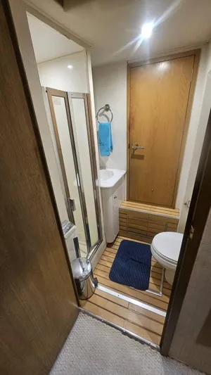  Yacht Photos Pics Bathroom interior of 1999 Hatteras 65 Convertible yacht, featuring shower, sink, and toilet.