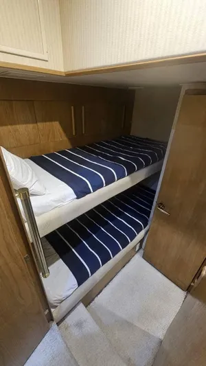  Yacht Photos Pics Bunk beds in 1999 Hatteras 65 Convertible yacht cabin with striped bedding.
