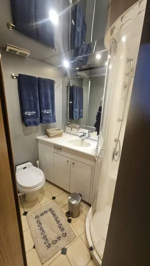  Yacht Photos Pics Bathroom interior of 1999 Hatteras 65 Convertible yacht, featuring shower, sink, and toilet.