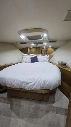  Yacht Photos Pics 1999 Hatteras 65 Convertible yacht bedroom with cozy bed and modern lighting.