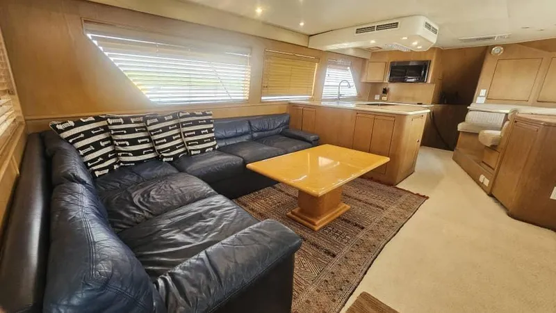 Yacht Photos Pics Luxurious interior of 1999 Hatteras 65 Convertible yacht with leather seating and wooden accents.