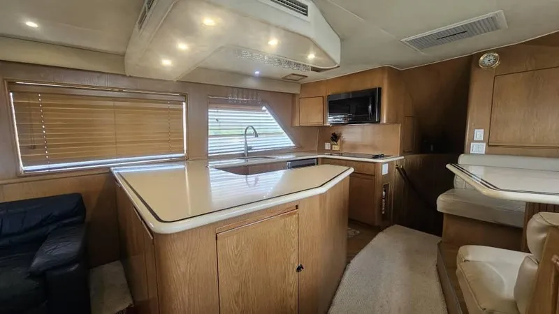  Yacht Photos Pics Interior of 1999 Hatteras 65 Convertible yacht with modern kitchen and seating area.