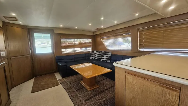  Yacht Photos Pics Luxurious interior of 1999 Hatteras 65 Convertible yacht with wood accents and cozy seating.