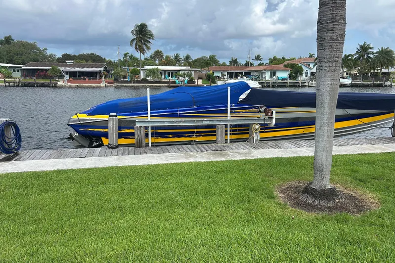  Yacht Photos Pics 2008 Nor-Tech 4300V boat docked by waterfront homes, under cloudy sky.