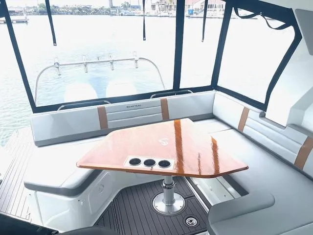 Fortuna Yacht Photos Pics 2022 Beneteau 32 Gran Turismo yacht interior with sleek seating and polished wood table.