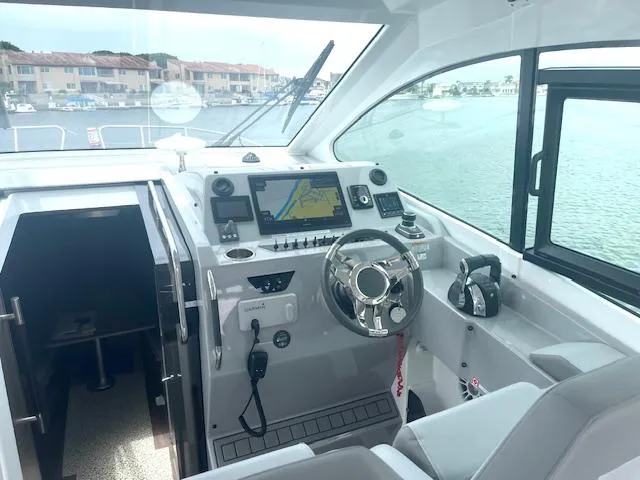 Fortuna Yacht Photos Pics 2022 Beneteau 32 Gran Turismo helm with navigation system and waterfront view.