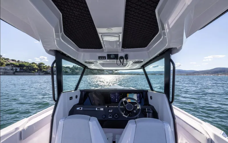  Yacht Photos Pics 2025 Axopar 29 CCX boat interior with modern dashboard and scenic water view.