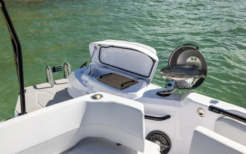  Yacht Photos Pics 2025 Axopar 29 CCX boat with outdoor grill and storage, on calm water.