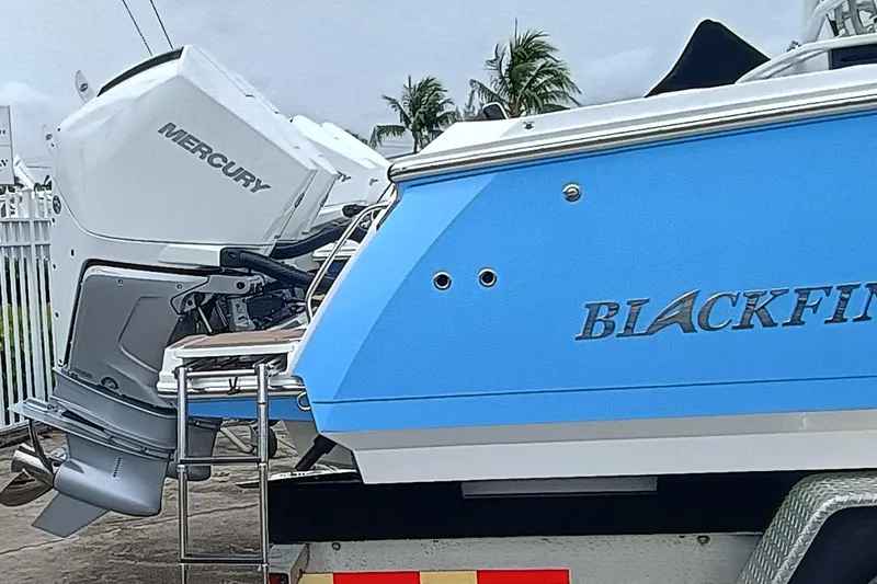 272-499 Yacht Photos Pics 2025 Blackfin 272 CC boat with Mercury engine, blue hull, parked on trailer.