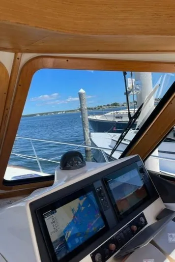 Black Bird Yacht Photos Pics 2006 Sabre 38 Hard Top Express helm with navigation screens, docked by the water.