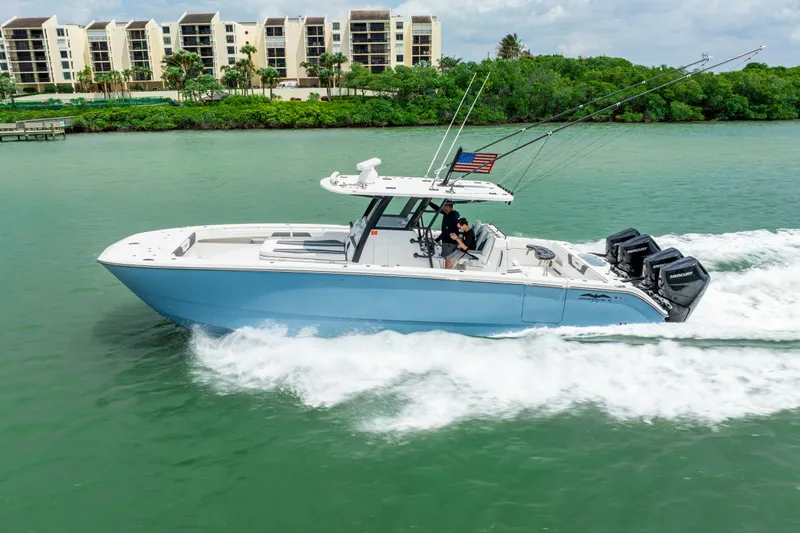 Kroppdustr Yacht Photos Pics 2023 Invincible 37 Catamaran cruising on water with modern buildings in the background.