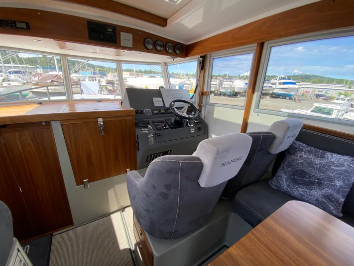 Ursa Yacht Photos Pics Interior of 2019 Sargo 36 Explorer boat with helm, wooden cabinetry, and marina view.