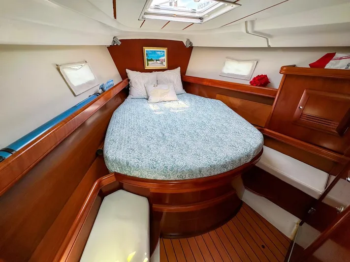 Yumi III Yacht Photos Pics Luxurious cabin interior of 2005 Beneteau 423 sailboat with cozy bed and wooden finish.