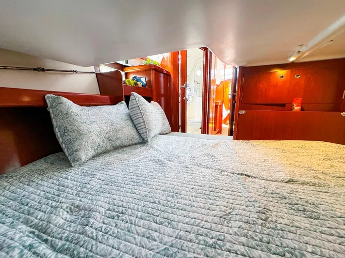Yumi III Yacht Photos Pics Cozy cabin interior of 2005 Beneteau 423 sailboat with comfortable bedding.