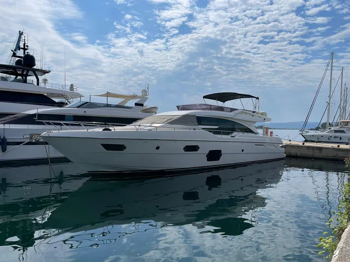  Yacht Photos Pics 2012 Ferretti Yachts 690 docked in a marina under a partly cloudy sky.