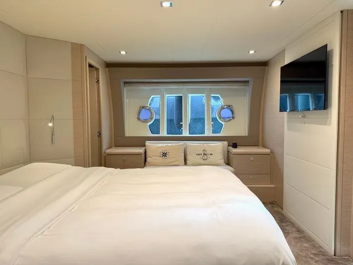  Yacht Photos Pics Luxurious bedroom interior of 2012 Ferretti Yachts 690 with modern decor and porthole windows.