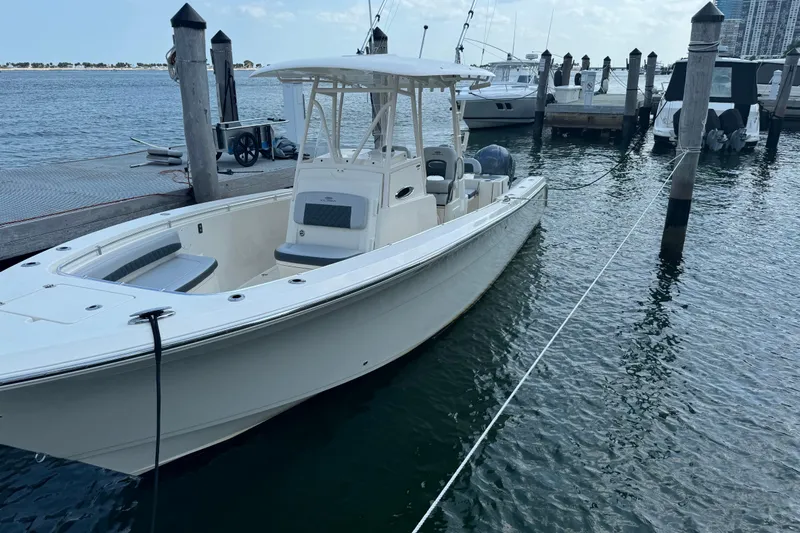 No Name Yacht Photos Pics 2018 Cobia 301 Center Console boat docked at marina, calm water background.