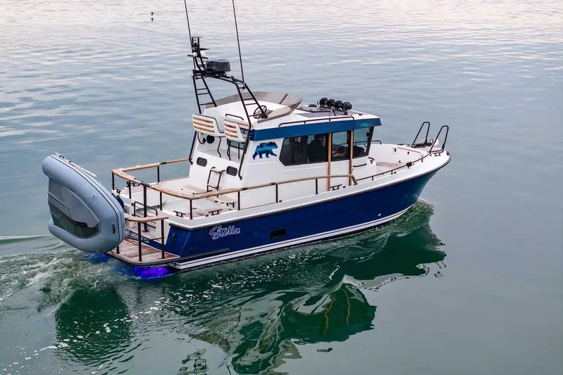  Yacht Photos Pics 2024 Targa 27.2 boat cruising on calm water, featuring a sleek blue and white design.