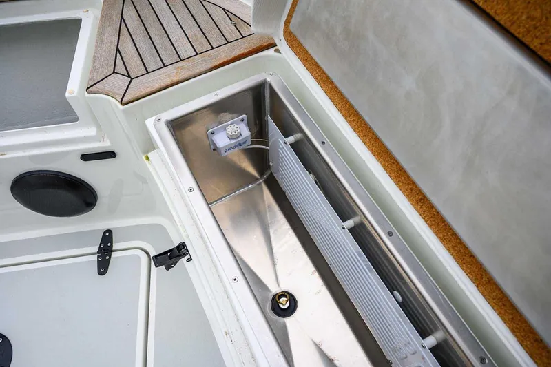  Yacht Photos Pics 2024 Targa 27.2 boat storage compartment with stainless steel interior and wooden deck detail.