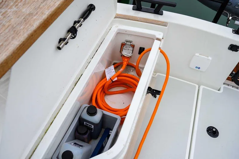  Yacht Photos Pics Storage compartment of 2024 Targa 27.2 boat with orange cable and containers.