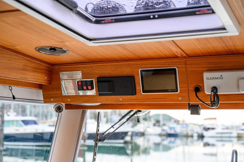  Yacht Photos Pics 2024 Targa 27.2 boat interior with wooden paneling and navigation equipment.