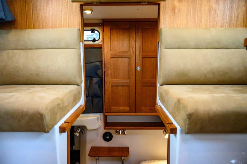  Yacht Photos Pics Interior of 2024 Targa 27.2 boat with wooden cabinetry and cushioned seating.