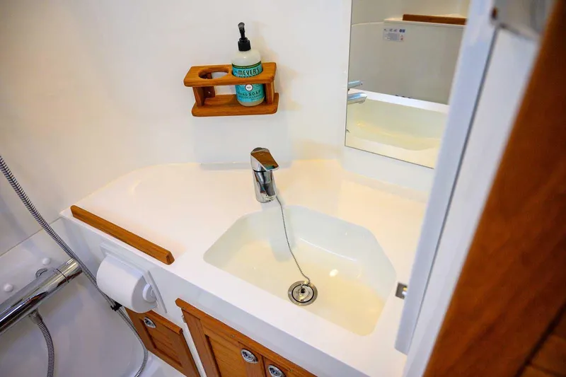 Yacht Photos Pics Modern bathroom sink in 2024 Targa 27.2 boat, featuring wooden accents and soap dispenser.