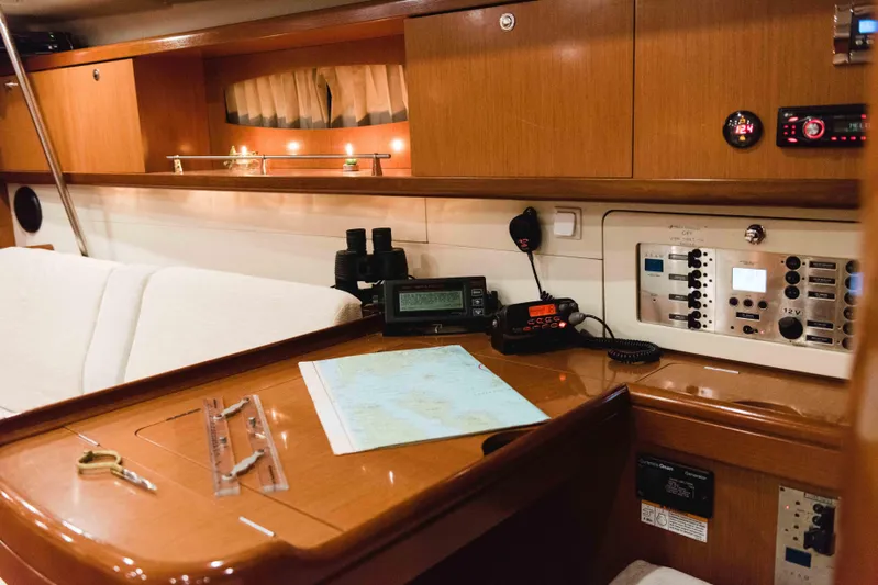  Yacht Photos Pics Navigation station inside 2009 Beneteau Oceanis 54 yacht with map, instruments, and cozy seating.