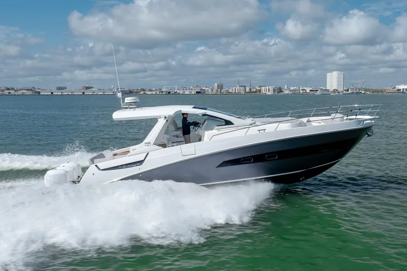  Yacht Photos Pics 2019 Azimut Verve 40 yacht cruising on open water, city skyline in background.