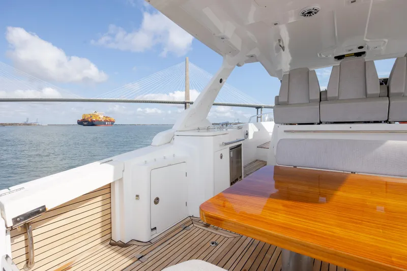  Yacht Photos Pics 2019 Azimut Verve 40 yacht interior with wooden table, ocean view, and bridge in background.