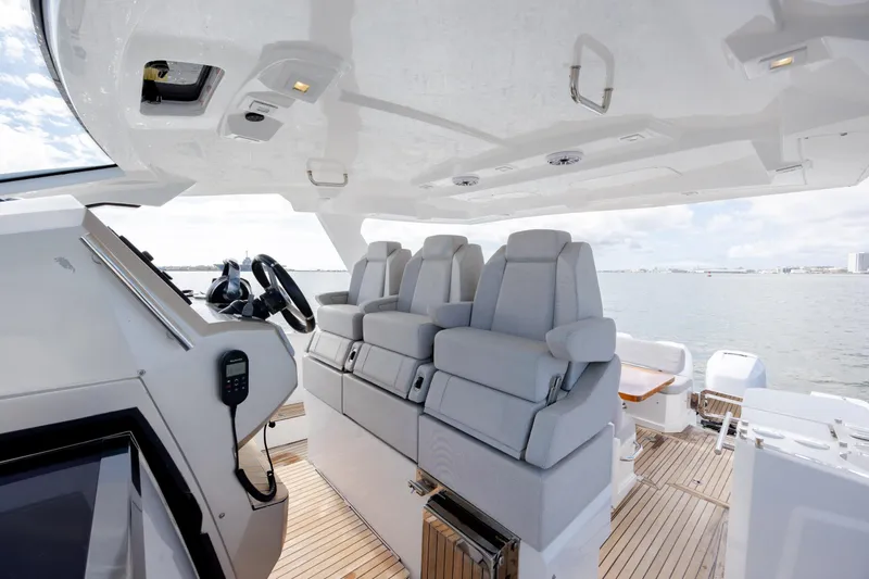  Yacht Photos Pics 2019 Azimut Verve 40 yacht interior with modern seating and steering console, overlooking the ocean.