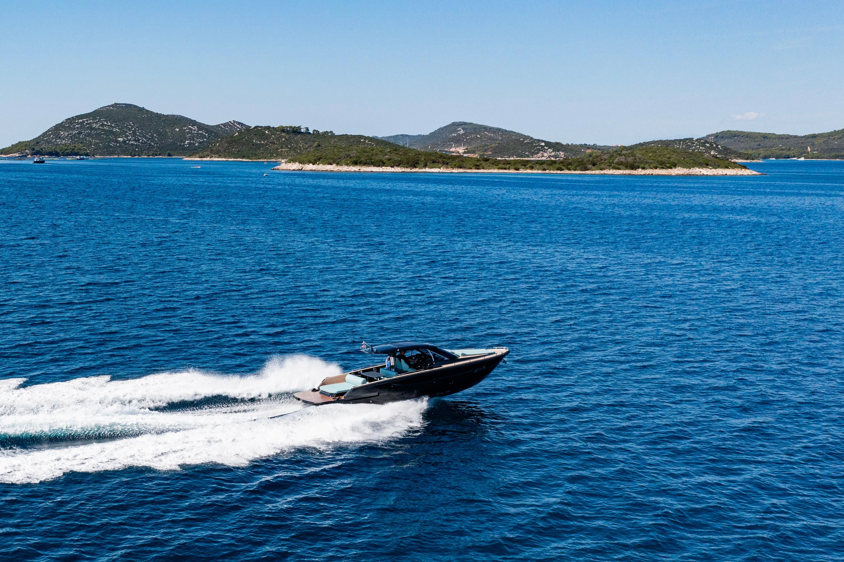2023 Focus Forza 37 speedboat cruising on blue ocean near scenic islands.