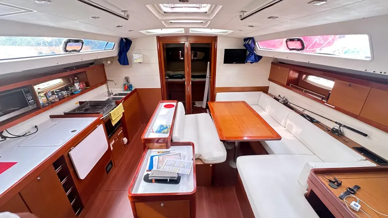  Yacht Photos Pics Interior of 2010 Beneteau Oceanis 50 yacht, featuring kitchen and dining area with wood finishes.
